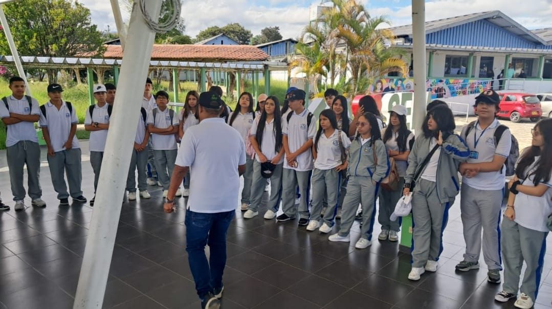 Estudiantes en salida pedagógica escuchando a un docente